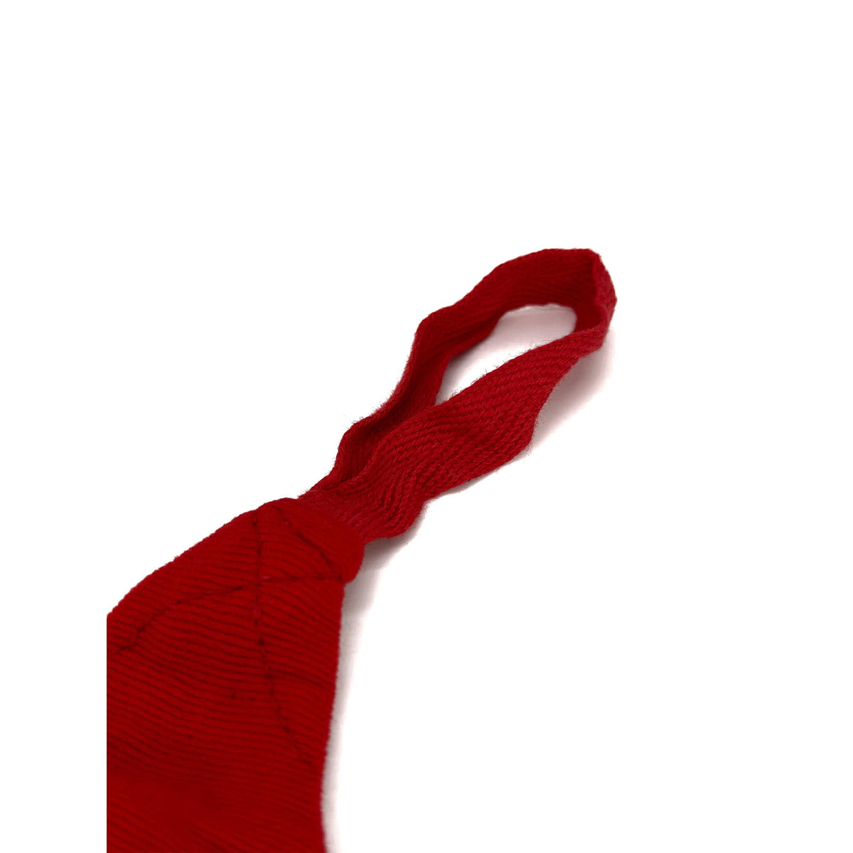Nahaufnahme der Daumenschlaufe an der roten Boxbandage, hervorgehoben durch ihr präzises Design für zusätzlichen Halt und einfaches Anlegen. Die Schlaufe gewährleistet eine sichere Positionierung der Bandage um Hand und Handgelenk für optimalen Schutz beim Training.