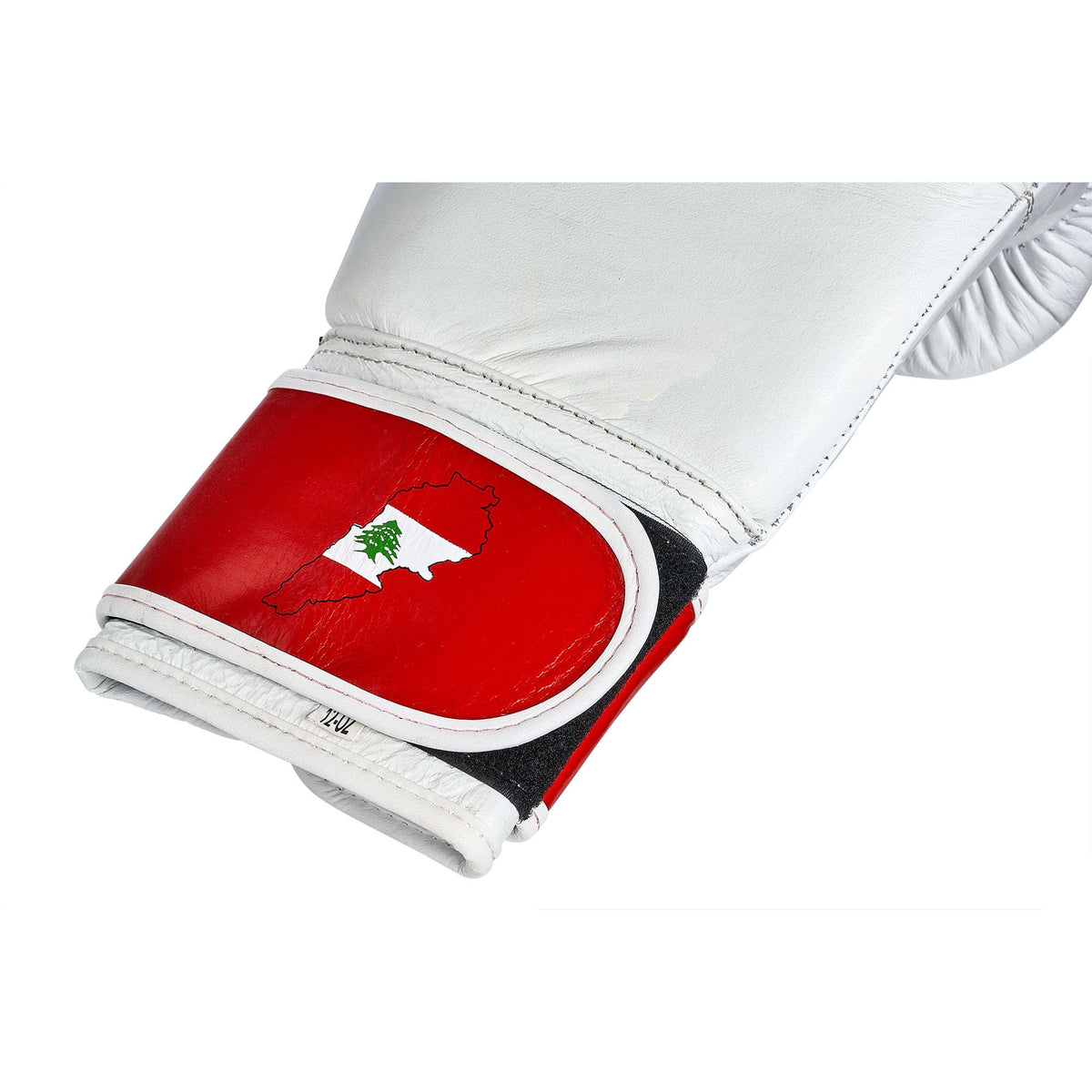 Nahaufnahme des Klettverschlusses am Handgelenk libanesischer Boxhandschuhe, die den Umriss des Libanons und die libanesische Flagge integriert zeigen. Diese Detailaufnahme unterstreicht das einzigartige Design, das die Handschuhe ziert, und betont gleichzeitig die hohe Qualität und Funktionalität. Hergestellt aus strapazierfähigem Leder, sichern die Handschuhe Langlebigkeit und bieten optimalen Schutz für Boxer aller Erfahrungsstufen.